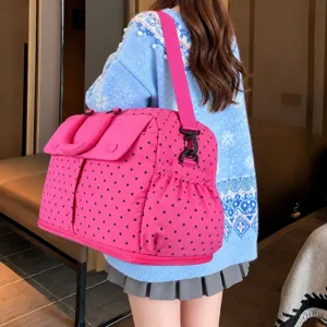 Detailed view of large capacity pink polka dot travel duffel bag, showing back carry style.