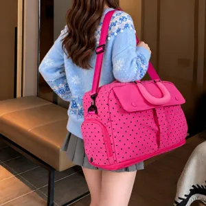 Close-up detail showing the pink polka dot travel bag's shoulder strap and side pocket design.