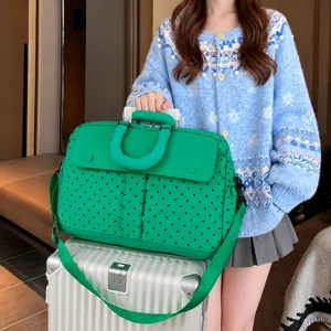 Green polka dot travel duffel bag detail showcasing large capacity and stylish design.