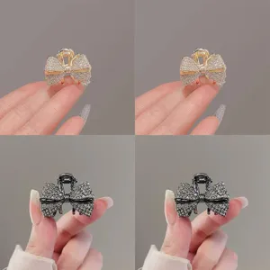 Détail de mini pince à cheveux nœud strass, accessoire brillant élégant pour coiffure chic.