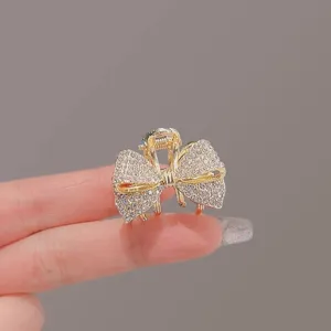 Pince à cheveux nœud papillon strass dorée, petit accessoire cheveux métal pour femme élégante.