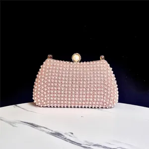 Vista detallada del elegante bolso de noche de perlas hecho a mano con cierre dorado.