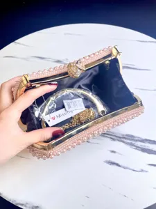 Elegante bolso de mano tipo clutch de perlas hecho a mano con marco de metal para eventos.