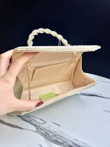 Interior detail of gold rhinestone evening bag, featuring chain strap and pocket lining.