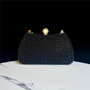 Vista detallada del elegante bolso de noche con cuentas negras y cierre de perlas de lujo.