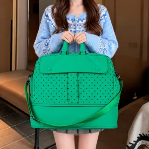 Green polka dot travel duffel bag detail showing large capacity, durable fabric and handles.