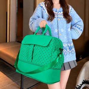 Detailed view of the large capacity green polka dot travel duffel bag with expandable base.