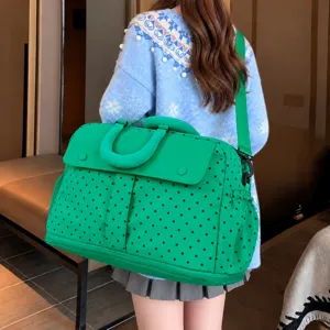 Green polka dot travel duffel bag detail showcasing large capacity and comfortable shoulder strap for trips.