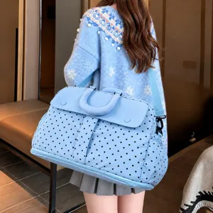 Detailed view of the large capacity polka dot travel duffel bag showcasing wearing effect.