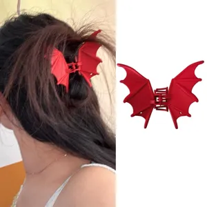 Vue détaillée de la pince à cheveux rouge en forme d'aile de chauve-souris gothique et style punk.