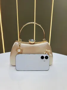 Elegant luxury gold satin evening clutch bag with pearl diamond clasp for party.