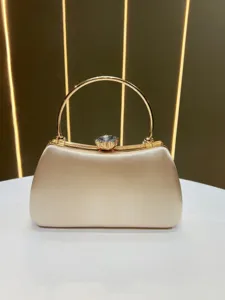 Elegant beige satin evening clutch with chic gold round handle and sparkly crystal clasp detail.