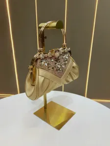 Close-up of gold rhinestone evening handbag with metallic handle and sparkling crystal details.