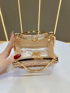 Pearl rhinestone evening clutch bag featuring metal handle and elegant gold chain detail