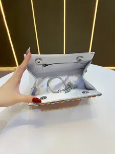 Silver rhinestone evening clutch bag interior detail, luxury party handbag with chain strap.