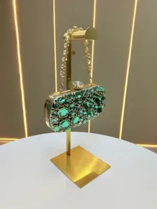 Green crystal evening clutch bag detail showing luxurious sparkling green rhinestones and gold chain.