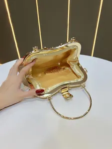 Close-up view of the golden metallic evening handbag interior lining and exquisite chain detail.