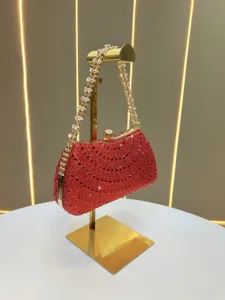 Red rhinestone evening clutch bag with gold chain strap detail, luxurious party handbag.