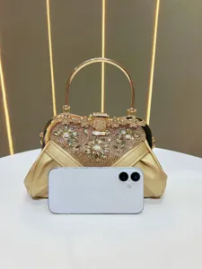 Detailed view of the luxurious gold rhinestone evening bag featuring an elegant metal ring handle.