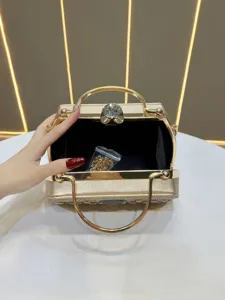 Gros plan détaillé du sac de soirée doré de luxe en strass avec poignées en métal chic.