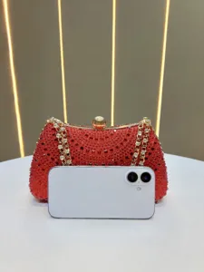 Red rhinestone evening clutch bag with gold metal frame, elegant chain strap and clasp.