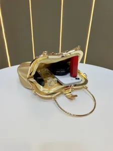 Gold evening handbag detail showing spacious interior capacity with cosmetic props inside.
