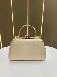 Detail de sac de soiree dore avec fermoir strass et elegante poignee metallique.