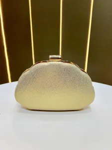 Golden glitter shell clutch bag detail, elegant evening purse with metal clasp.