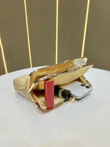 Detailed view of gold clutch evening bag interior capacity, showcasing phone and cosmetic storage.