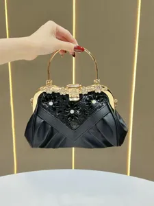 Exquisite crystal embellished evening handbag detail, elegant black clutch with gold handle.