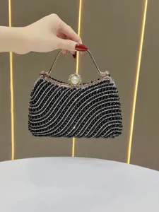Detailed view of black beaded evening clutch bag with pearl clasp and sparkling rhinestones.