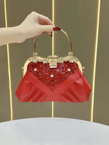 Detailed view of a red rhinestone evening clutch bag with elegant gold metal frame and handle.