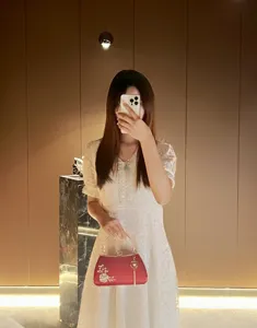 Exquisite red evening clutch bag with pearl floral inlay, metal ring handle and tassel pendant.