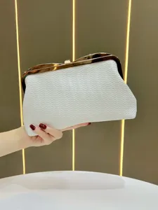 White textured clutch bag detail showing elegant gold metal frame clasp and premium faux leather.