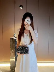 Vue détaillée d'un sac de soirée de luxe avec strass scintillants et poignée métallique.