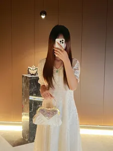 Detailed view of elegant white crystal heart evening bag with metal handle, perfect accessory.