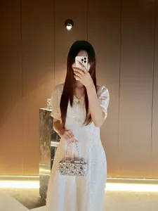 Detailed view of the sparkling rhinestone evening clutch bag with chain strap for luxury party dress.