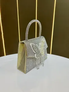 Detailansicht der wunderschönen Strass-Abendtasche mit funkelndem Schmetterling und Fransen.