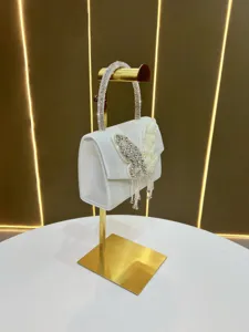 White satin evening handbag with rhinestone butterfly and tassel, elegant luxury style.