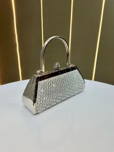 Detailed close-up of a glamorous silver rhinestone evening handbag featuring a sleek metallic handle.
