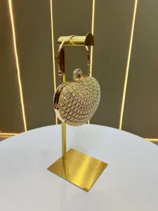 Vista dettagliata della borsa da sera a cuore con strass scintillanti sul supporto.