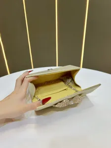 Detailed view of the sparkling gold evening clutch bag with a stunning crystal bow detail.