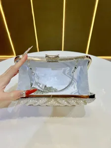Detail view of a luxury pearl and rhinestone evening clutch bag with silver chain strap.