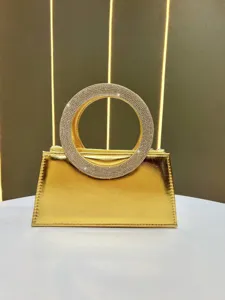 Exquisite gold metallic evening handbag featuring a stunning rhinestone encrusted round handle.