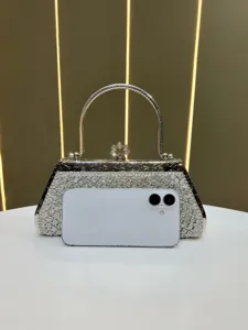 Detailed view of a sparkling rhinestone evening handbag with silver handle and crystal clutch.