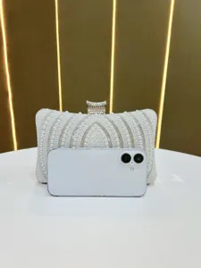 Detailed view of pearl evening clutch bag with rhinestone clasp for women banquet party.