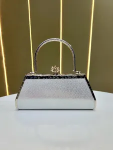 Close-up view of silver glitter evening bag featuring metallic handle and decorative clasp.