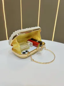 Elegant gold evening clutch bag with pearl trim and metal handle, perfect for luxury parties.