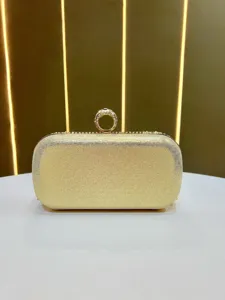 Vista detallada del bolso de mano de noche dorado brillante con cierre de anillo de strass.