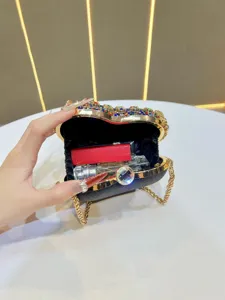 Heart-shaped rhinestone evening clutch detail showing inner capacity with chain strap.